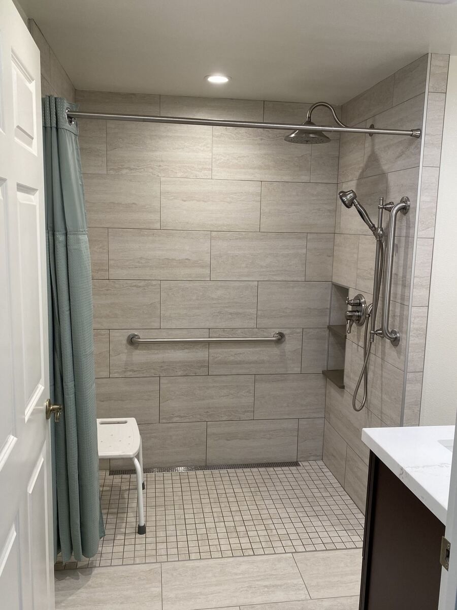 Roll-in shower with a fold-down bench, grab bars and a level threshold