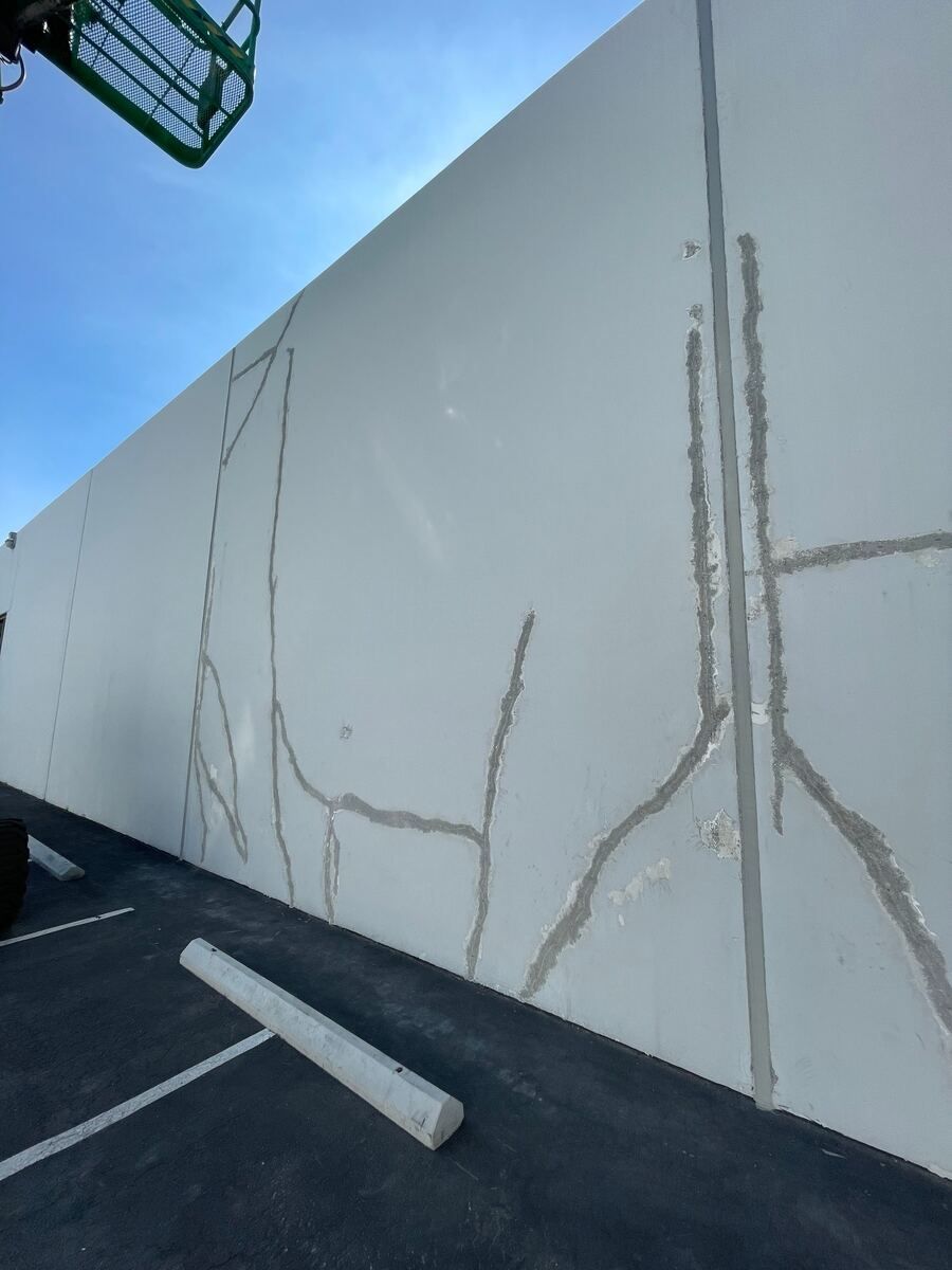 Crack runs routed and surface-sealed along a tilt-up panel