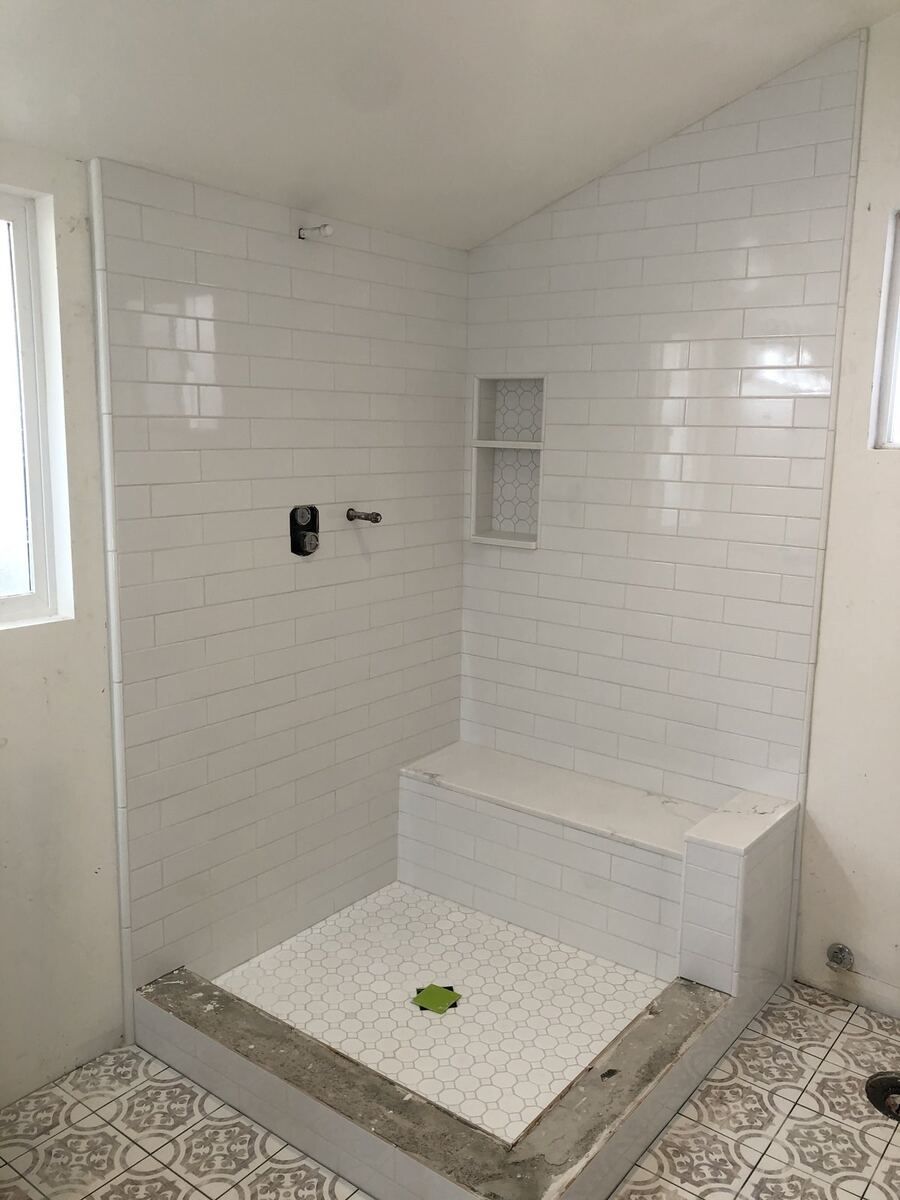 Tiled curbless shower with a built-in seat and a low threshold