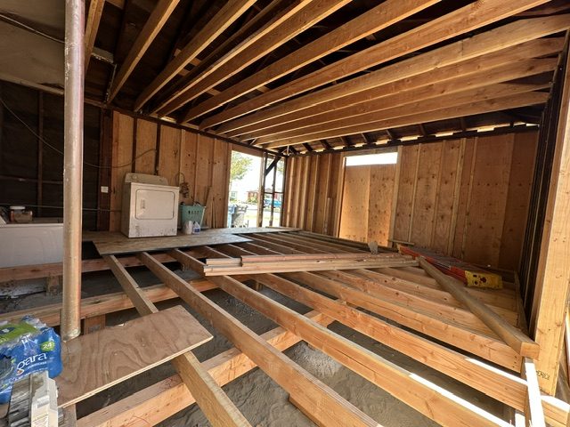 New floor joists going in over the soil, with the first subfloor sheets laid