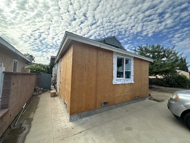 The sheathed ADU from the driveway, with a new window flashed in