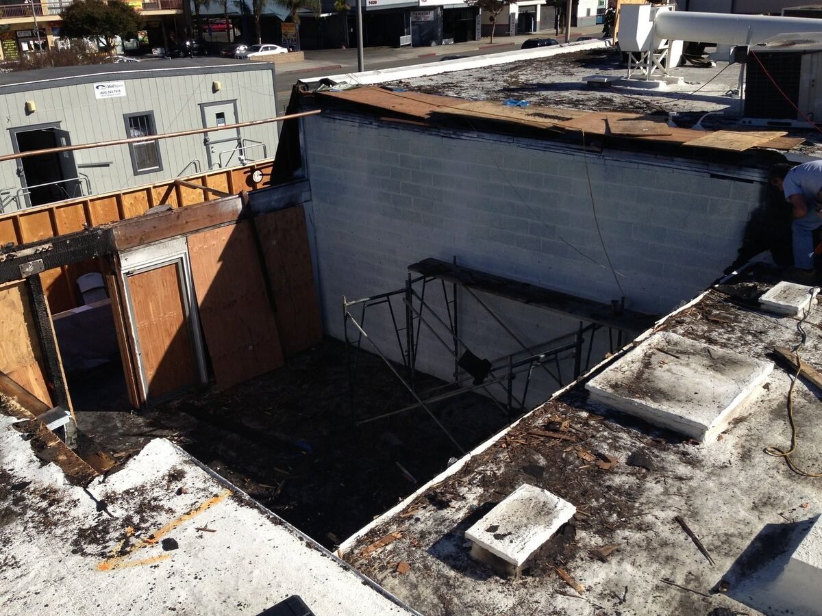 Roof burned through, structure open to the sky with debris below