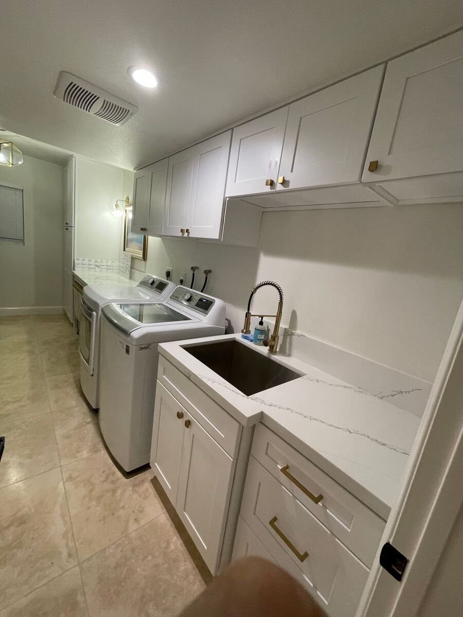 Designer laundry room with utility sink and custom cabinetry