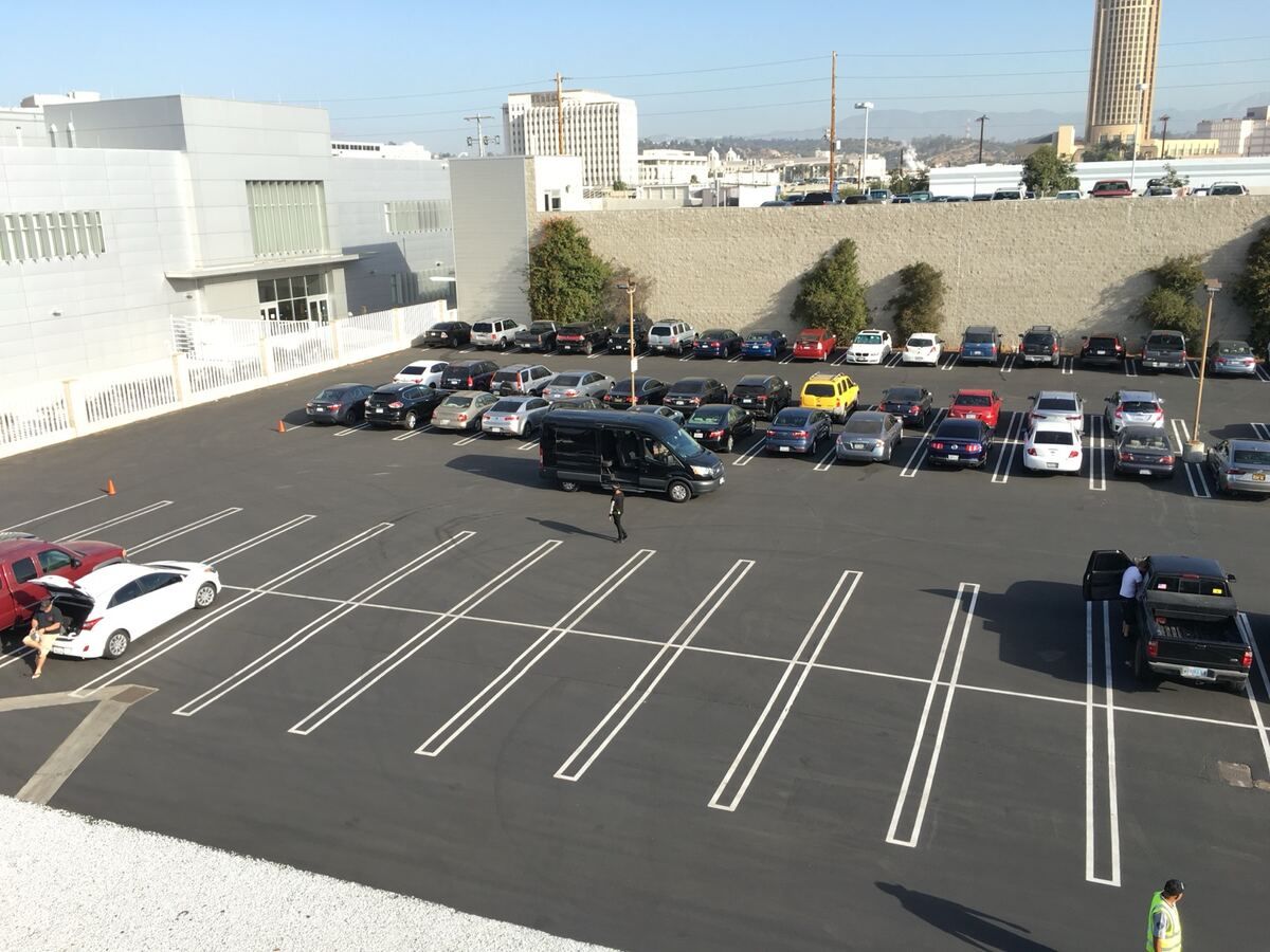 The same lot after seal coating, with fresh black asphalt and crisp white double-line stalls