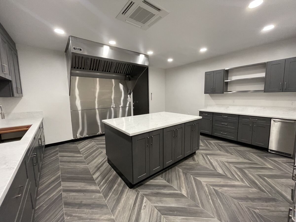 Finished kitchen with stainless hood and commercial refrigeration