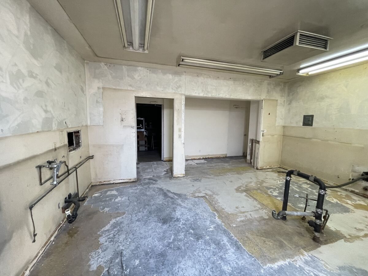 Demolition complete, bare concrete slab and stripped walls