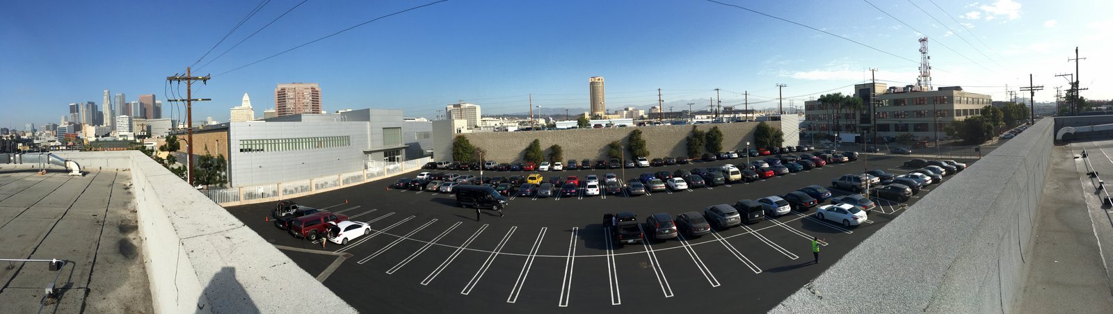 Finished parking lot seen from the roof, fresh black seal coat with crisp white stall lines