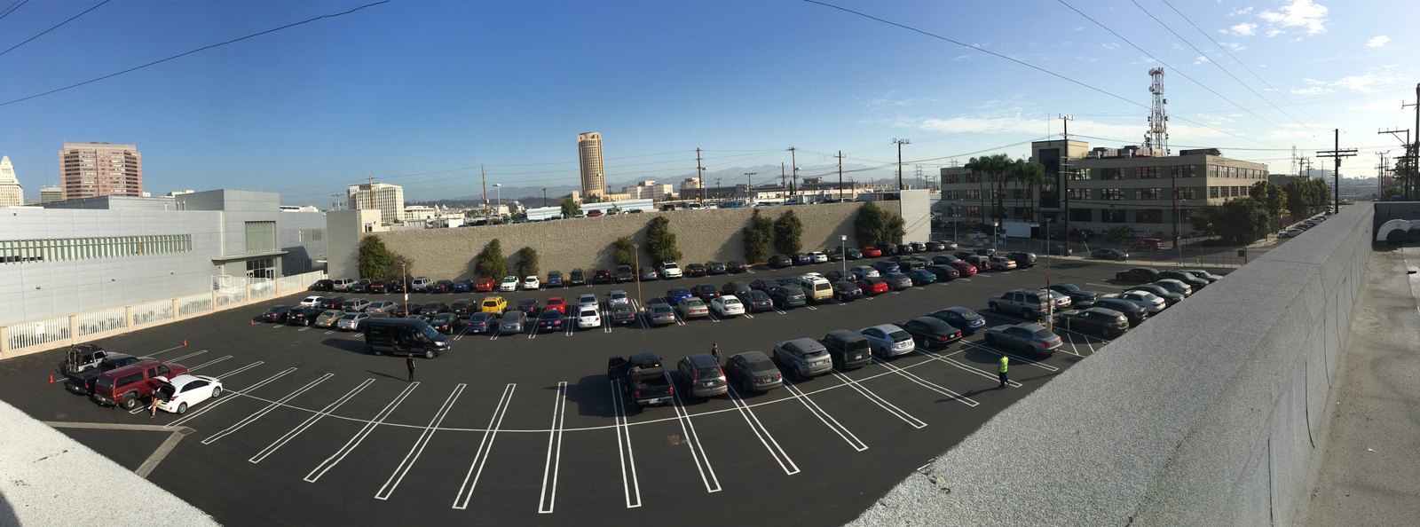 Roof-level view of the completed lot, jet-black seal coat with bright white stalls