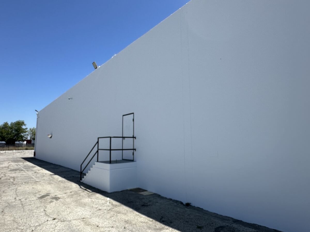 The same tilt-up wall after repair and repaint, clean and uniformly white