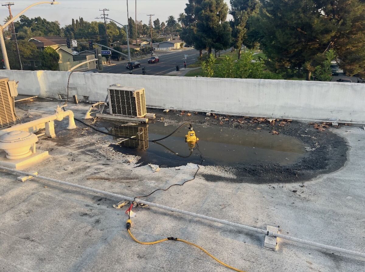 Standing water ponding on a flat commercial roof