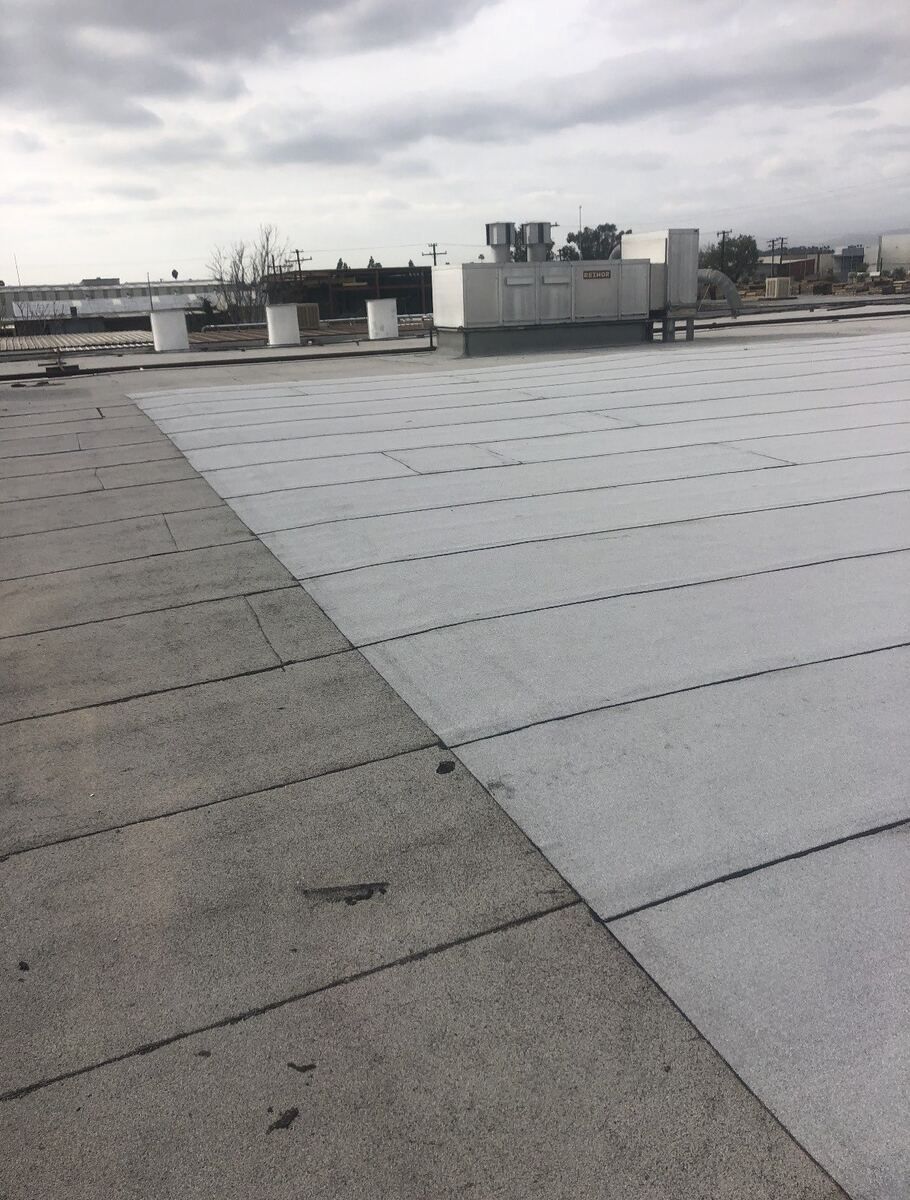 New light grey roof membrane laid in clean seamed runs across the same roof