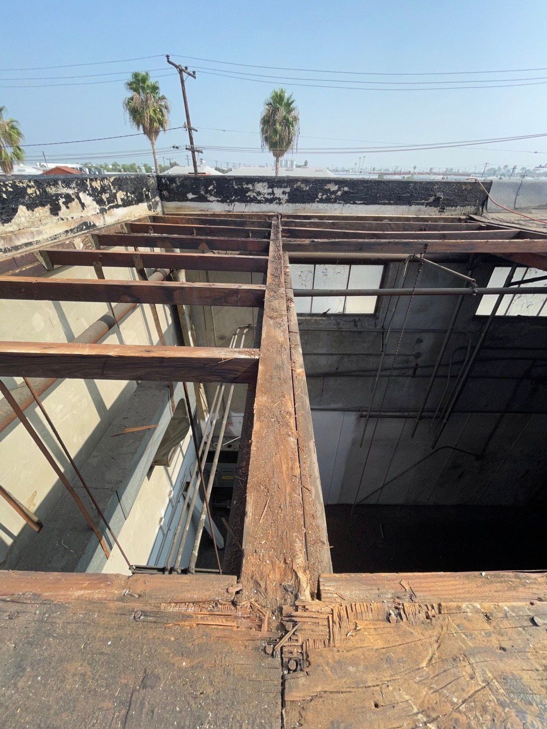 Replacement sub-purlin roof support beam set into a flat panelized commercial roof